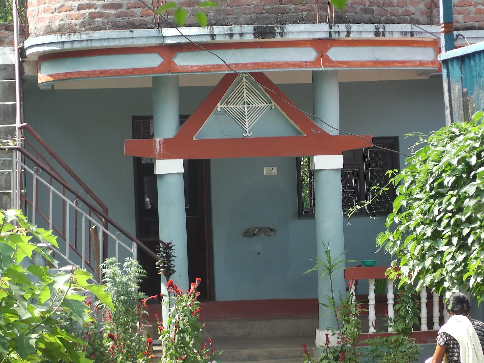 A modern house in Panchthar with a white diamond-shaped Silam Sakma mounted above the entrance.